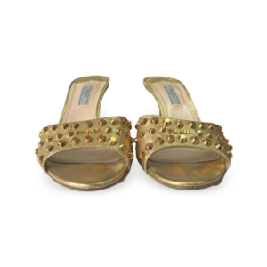 Gold slide sandals featuring a studded design on the upper strap.