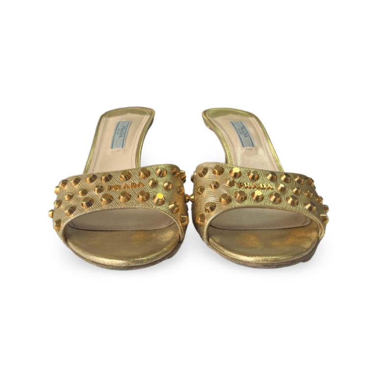 Gold slide sandals featuring a studded design on the upper strap.